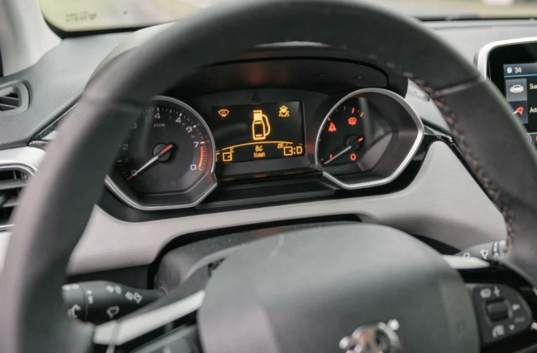 Tableau de bord d'une Peugeot 208 avec voyants lumineux allumés en orange et rouge indiquant des alertes moteur et batterie