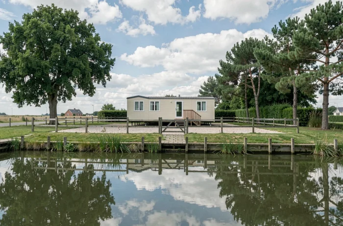 Vue depuis l'étang sur un terrain avec mobil-home en Vendée clôturé et arboré idéalement situé près de l'eau